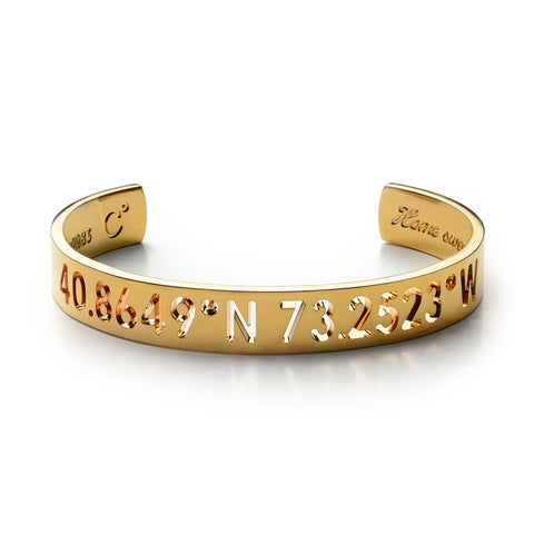 A gold cuff bracelet with carved out inscription