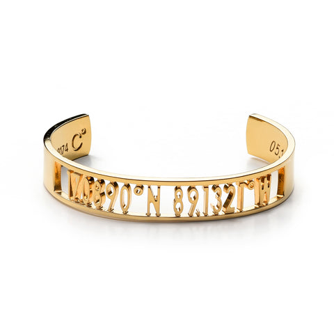 A wide gold cuff bracelet with carved out inscription