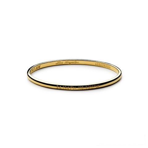 A delicate gold round bracelet with an exterior and interior inscription
