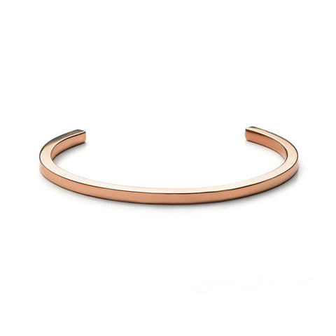 A thin, sleek gold cuff with squared ends and inscription